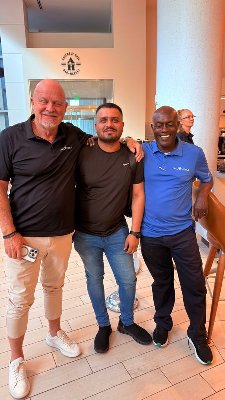 Wali Zuberi standing with two fellow attendees in the Contact.io 2026 conference venue in Denver